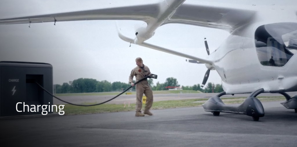 Photo of a man pulling a charging cord to connect with an electric airplane. Beta website photo.